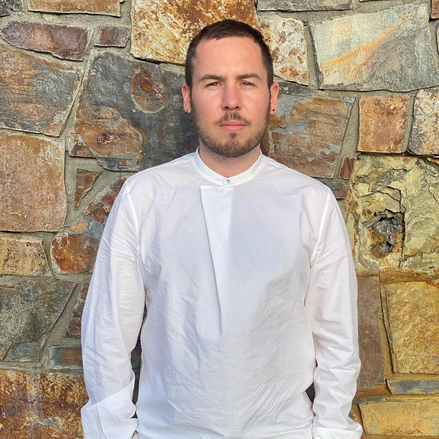 Michael R. Speciàle — portrait against white brick wall